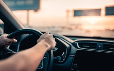 Close-up - Hand of man driving car on the road.